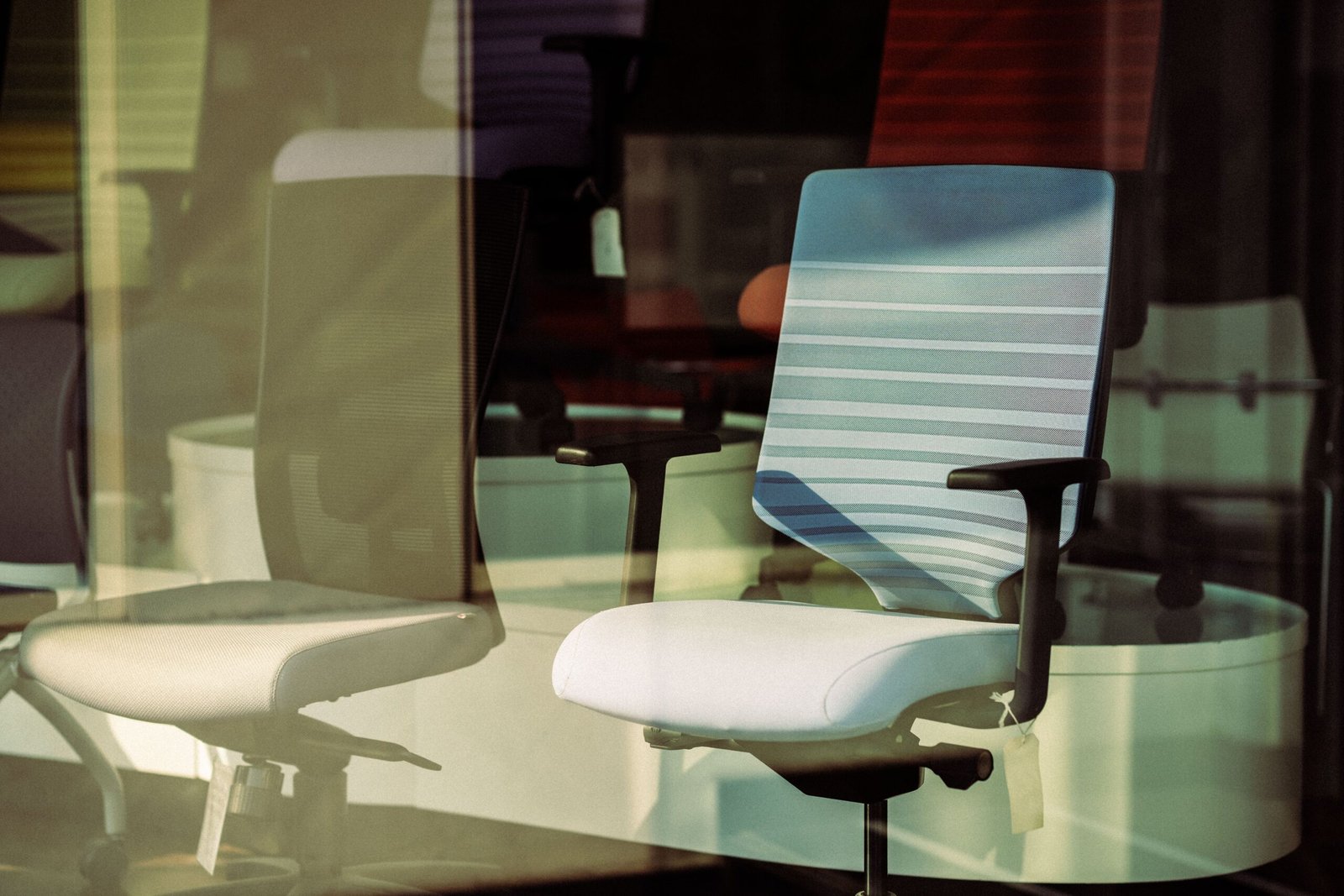Back support office chair displayed behind glass, offering modern ergonomic solutions for workspace.